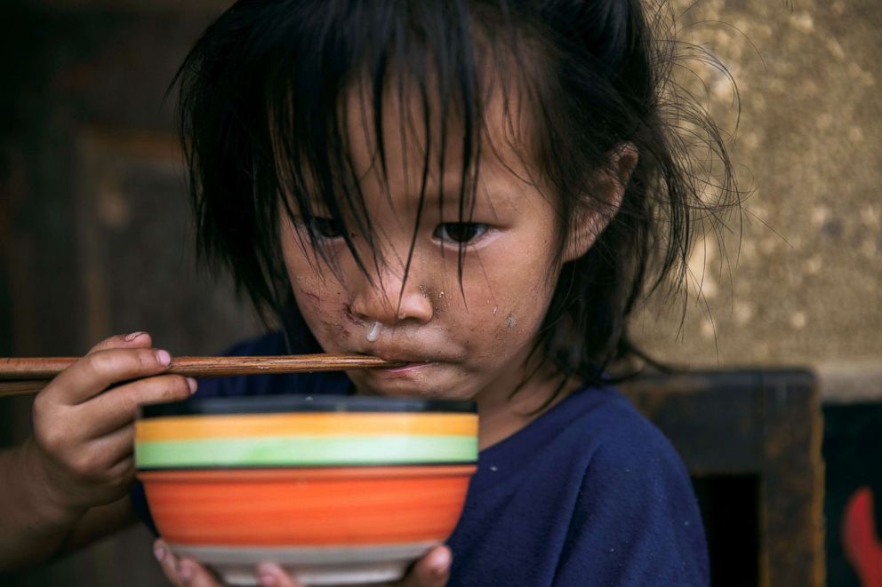 PHOTO: A girl eats her meal in a mountain village on an unnamed tributary of the fierce and flood-prone Dadu river near Leshan in Sichuan province, China, Aug. 3, 2018.