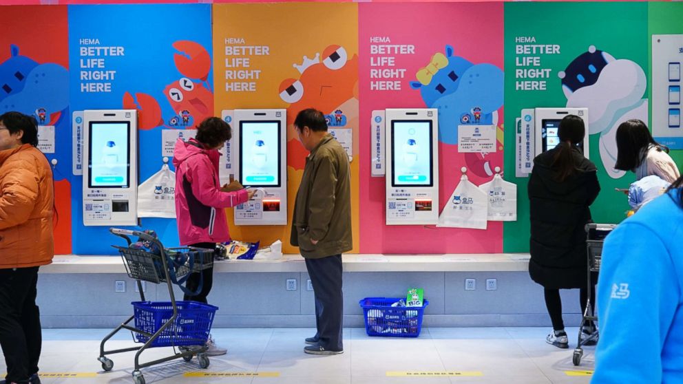 PHOTO: Shoppers use unmanned, cashless checkout machines to buy products with the Hema app on their phones in Beijing, Nov. 7, 2018.