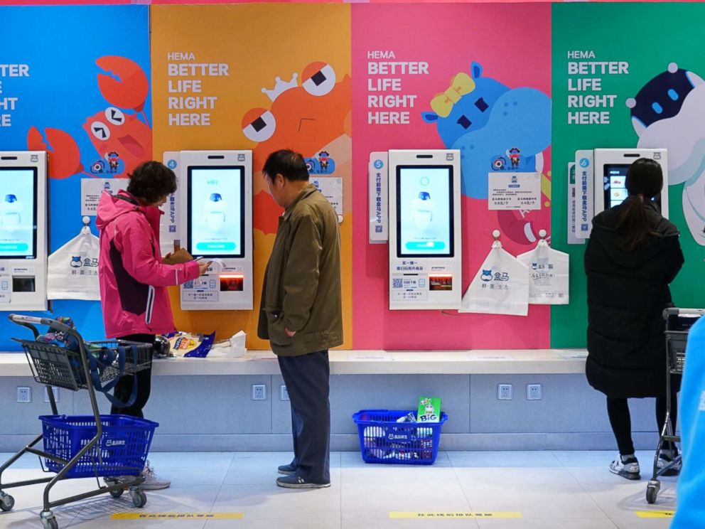 PHOTO: Shoppers use unmanned, cashless checkout machines to buy products with the Hema app on their phones in Beijing, Nov. 7, 2018.