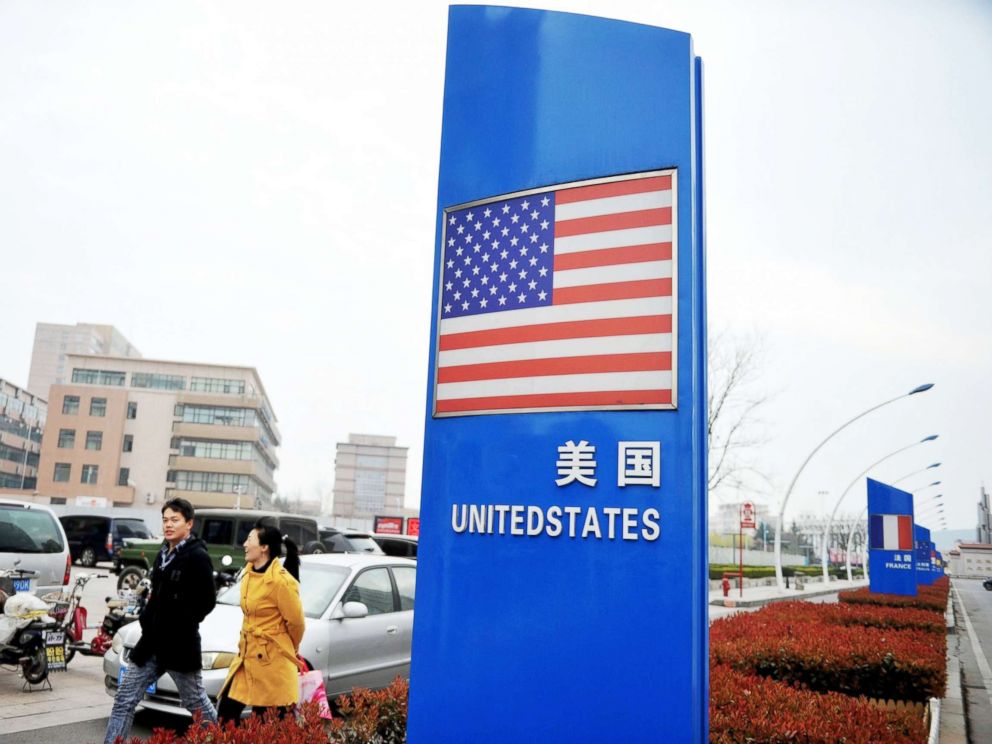 PHOTO: People walk by a sign for the United States in a bonded zone in Qingdao in east Chinas Shandong province, April 05, 2018.