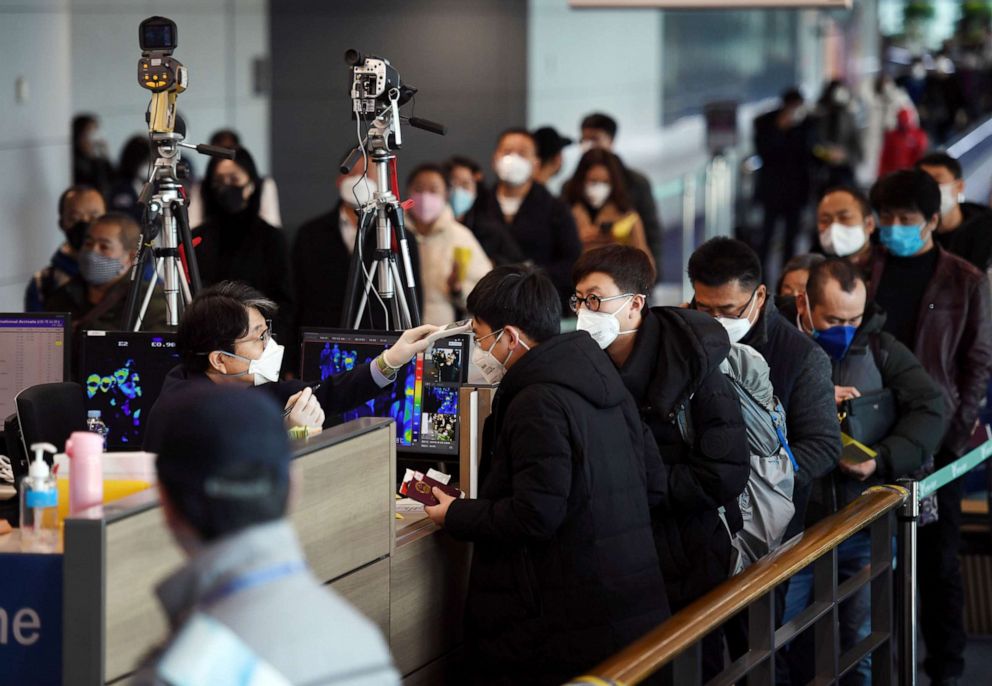 PHOTO: Passengers from China wearing masks to prevent a new coronavirus get checked for fever upon their arrival at Incheon International Airport in Incheon, South Korea, Jan. 29, 2020.