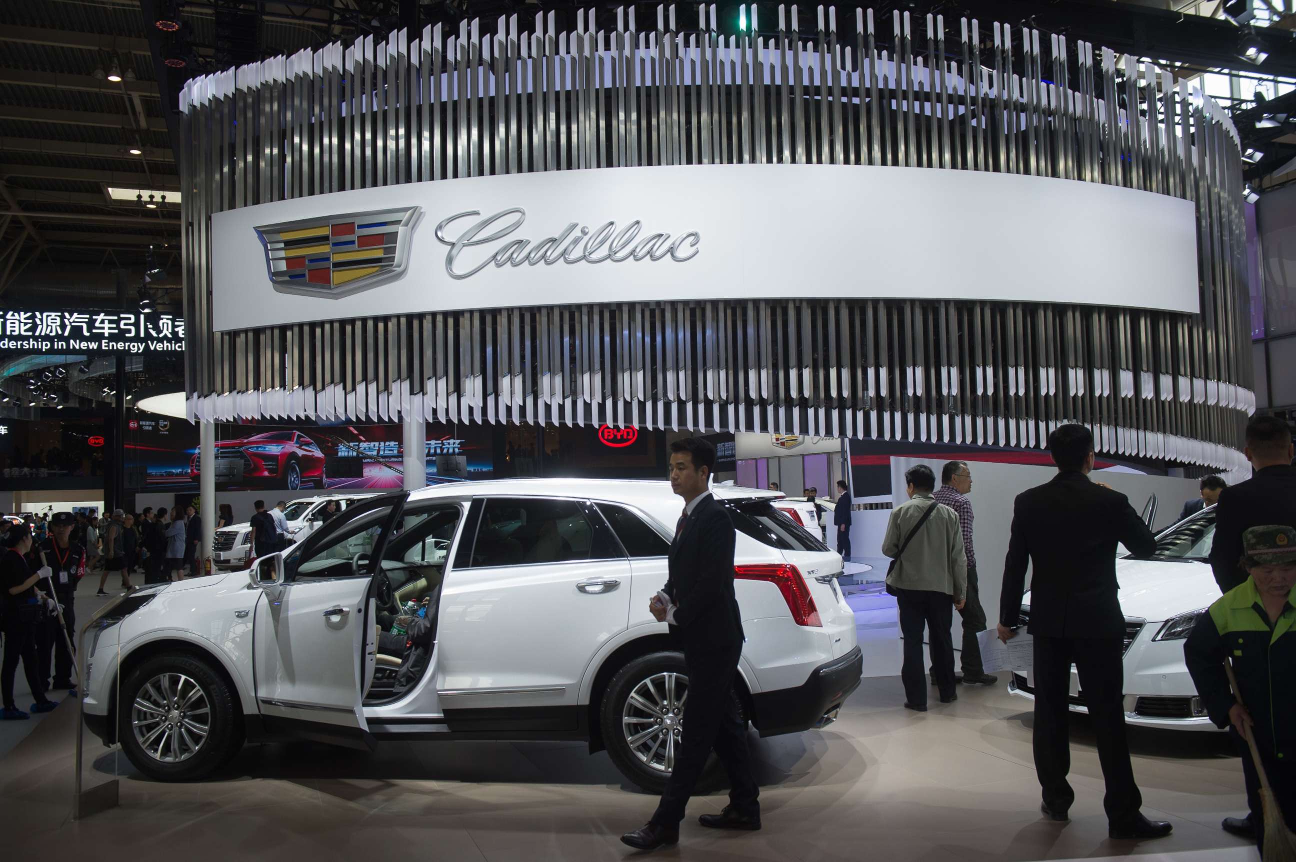 PHOTO: People walk through the Cadillac car display during the Beijing Auto Show in Beijing on April 25, 2018.