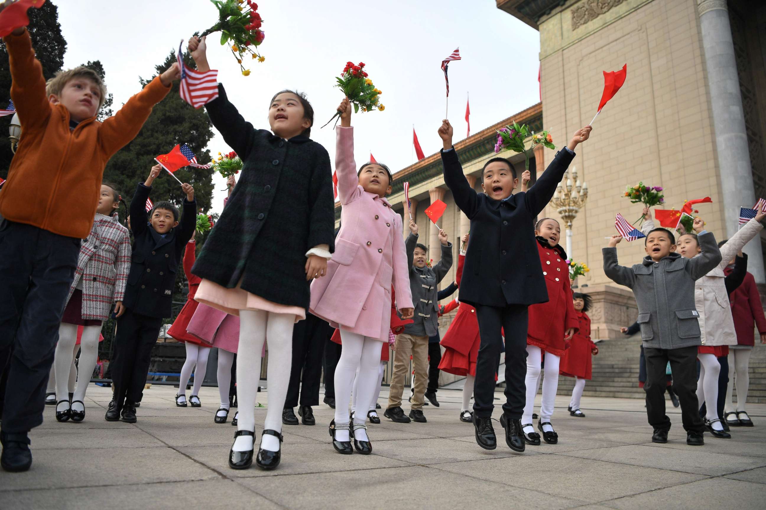 PHOTO: Children wave national flags before the arrival of China's President Xi Jinping and President Donald Trump during a welcome ceremony at the Great Hall of the People in Beijing on Nov. 9, 2017. 