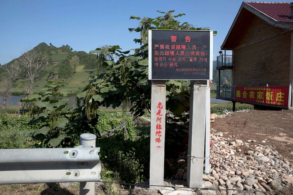 PHOTO: A sign in Chinese and Korean characters warns against harboring or feeding North Koreans who cross into a village near Linjiang, China, Aug. 30, 2017.