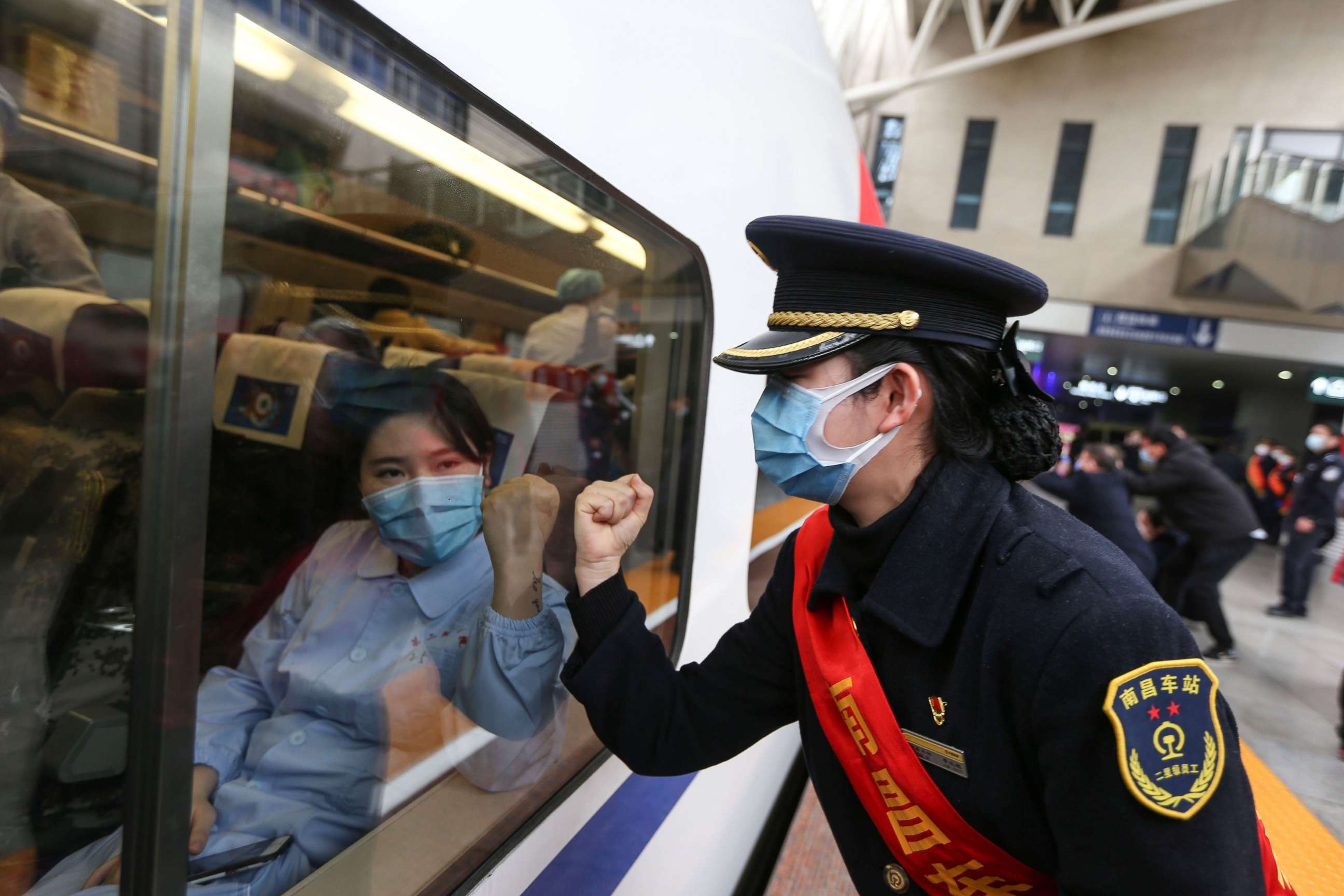 PHOTO: This photo taken on Feb. 13, 2020 in Nanchang, China, shows a train attendant gesturing to medical staff leaving for Wuhan, the epicenter of a novel coronavirus outbreak.