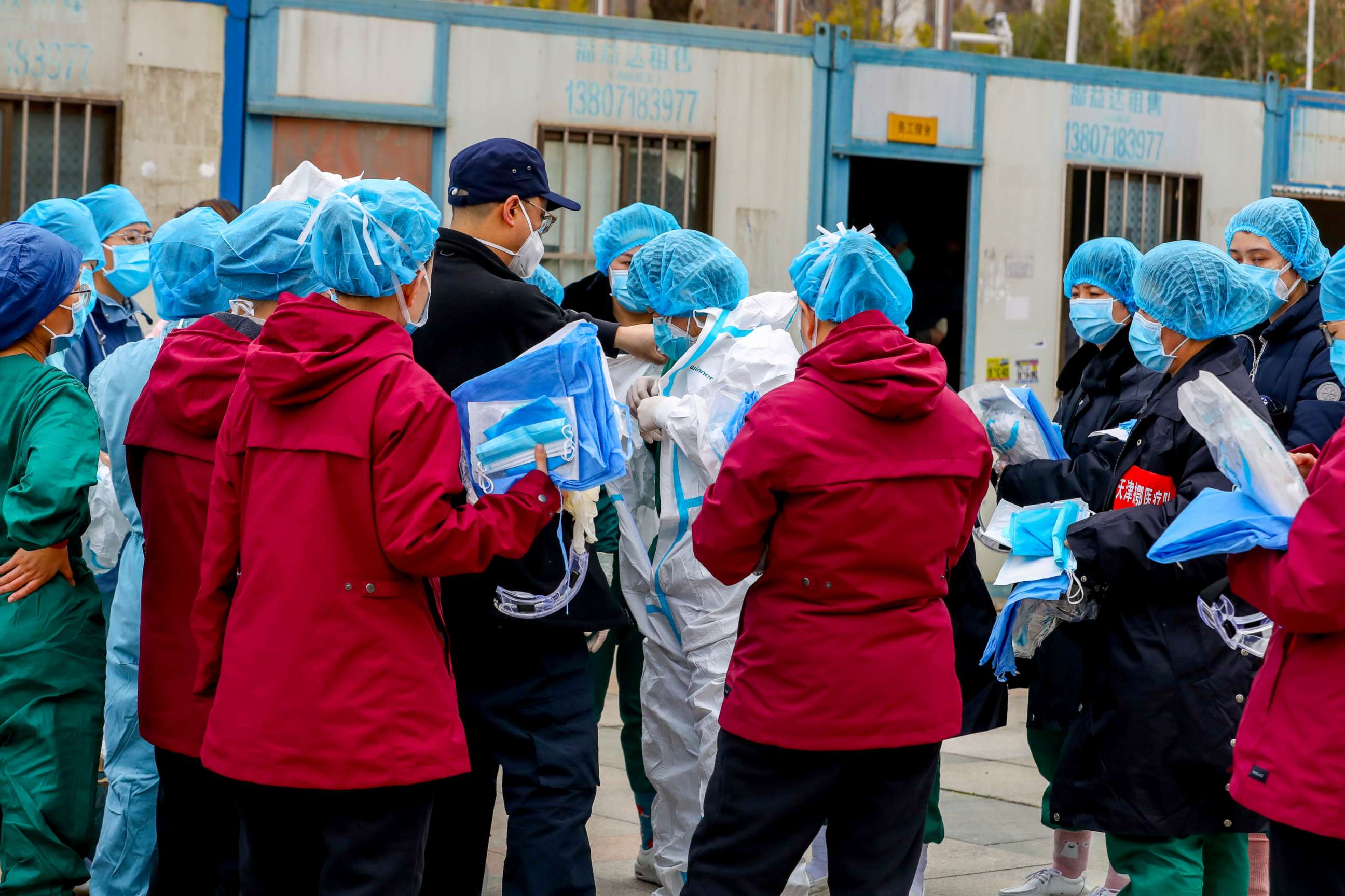 PHOTO: A medical worker puts on a protective suit before entering a sports center which has been converted into a makeshift hospital to treat patients of the novel coronavirus, in Wuhan, Hubei province, China, Feb. 12, 2020.