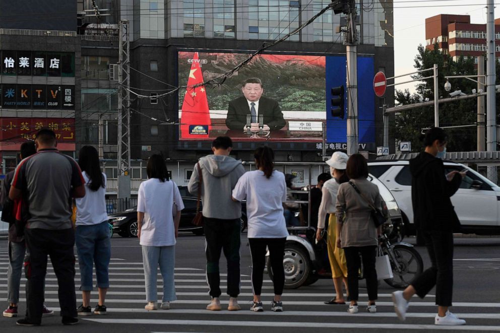 PHOTO: A news program shows Chinese President Xi Jinping speaking via video link to the 73rd World Health Assembly on a giant screen beside a street in Beijing on May 18, 2020.