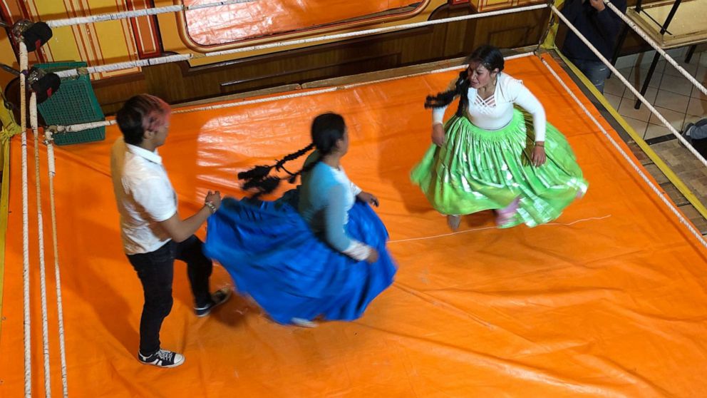 PHOTO: Cholita women wear large skirts and pigtails in the ring, and bowler caps outside of it.