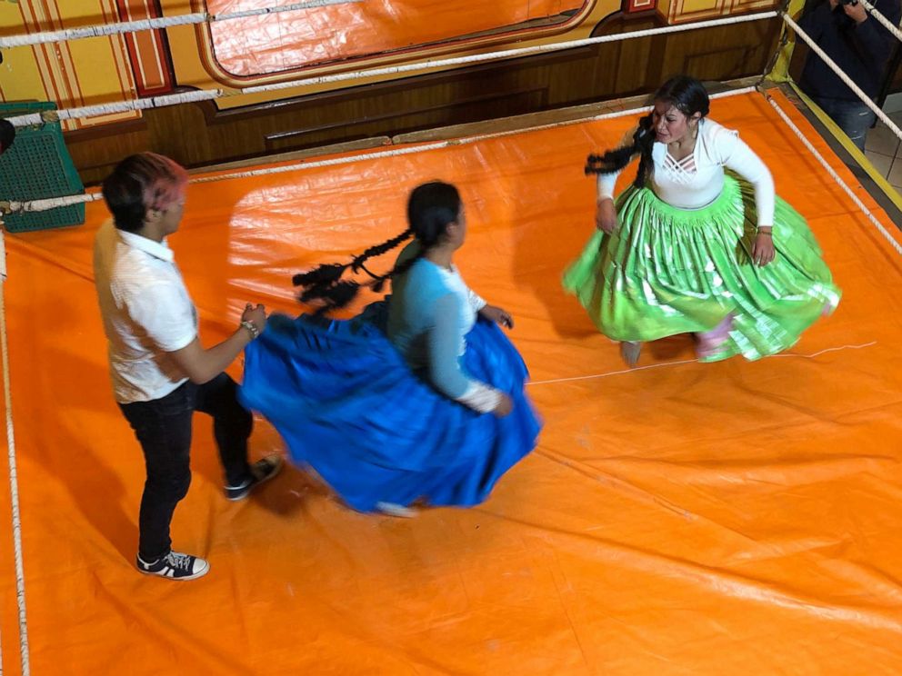 PHOTO: Cholita women wear large skirts and pigtails in the ring, and bowler caps outside of it.