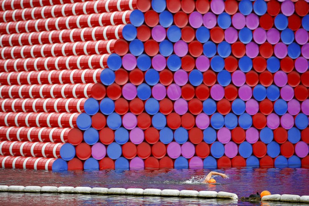 PHOTO: A swimmer excercises in the Serpentine River near Christo's "The London Mastaba," in Hyde Park, London, June 19, 2018.