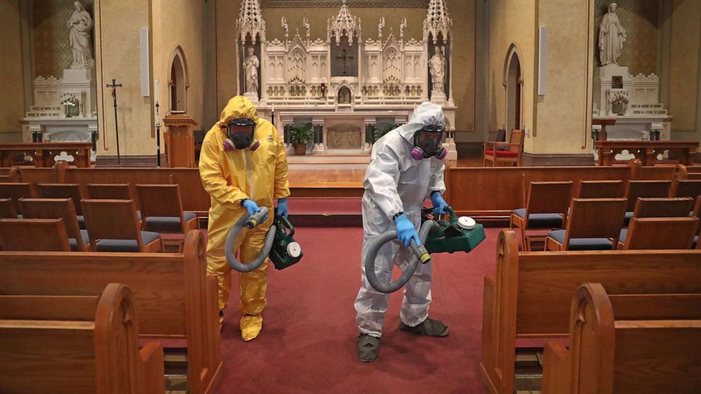 PHOTO: Mark Burgess, left, and David Rossini with Bostonian Cleaning and Restoration of Braintree cleans the aisle at St. Gregory's Church in Boston's Dorchester during the COVID-19 pandemic on May 18, 2020.