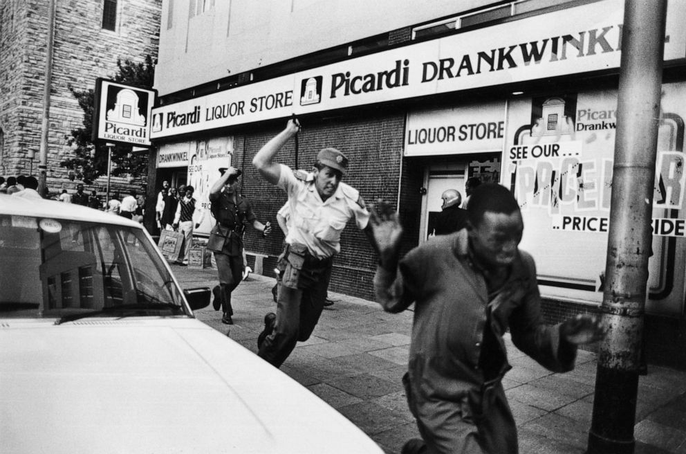 PHOTO: A South African police officer charges after a United Democratic Front demonstrator with a sjambok whip during a demonstration in Johannesburg, circa 1985.
