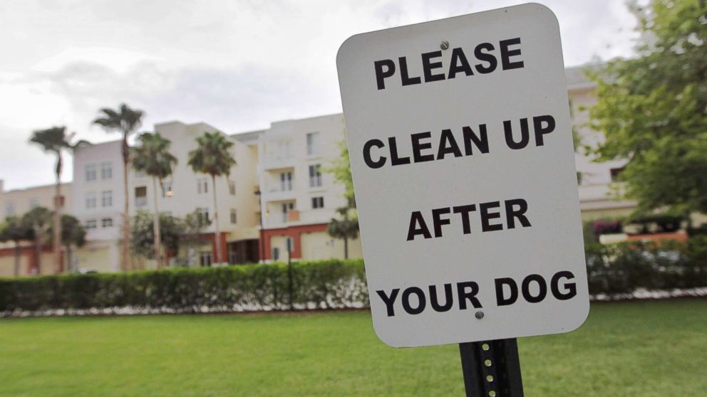 A sign is posted reading, " Please clean up after your dog"' in The Village of Abacoa condominium complex in this June 30, 2011 file photo in Jupiter, Fla.