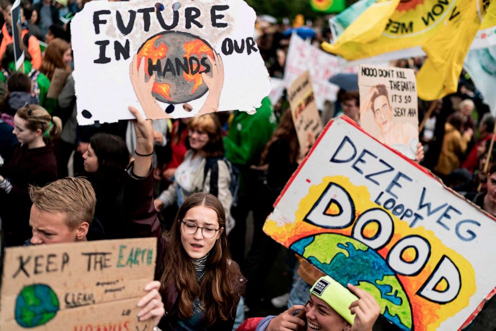 PHOTO: Protesters hold placards as they march during the Global Climate Strike organised by the "Fridays For Future" at the end of the global climate change week in The Hague, the Netherlands, on September 27, 2019.