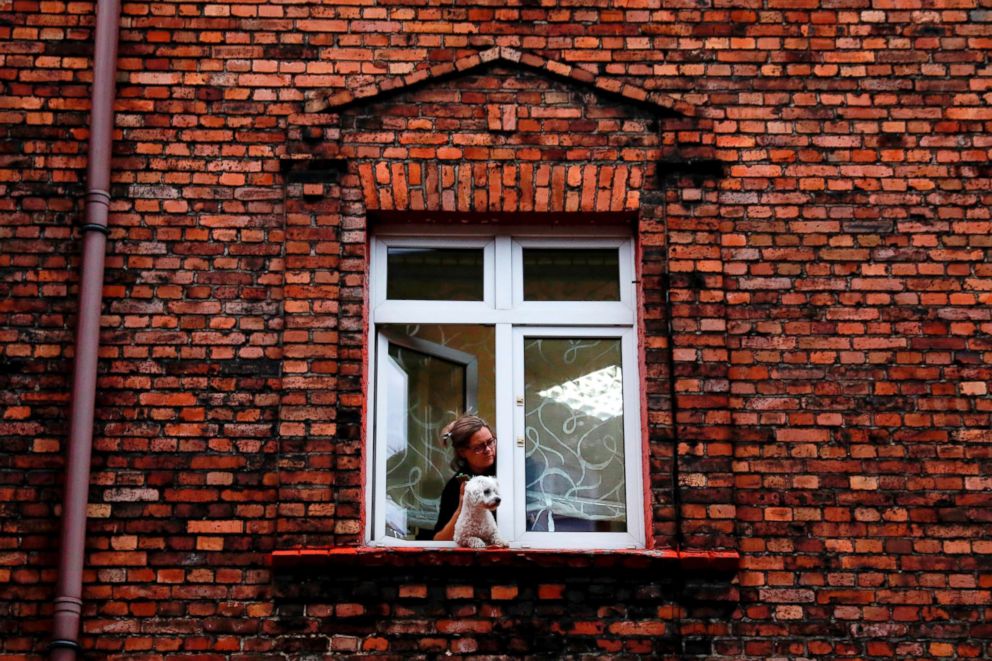 PHOTO: A woman with a dog look out from the window in Nikiszowiec district in Katowice, Poland, Oct. 17, 2018.