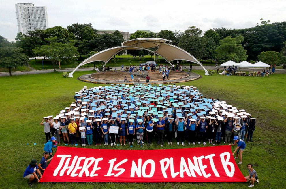 PHOTO: Environmental activists, mostly students, display their message in front of "a human globe" formation to coincide with the global protests on climate change Sept. 20, 2019, at the University of Philippines campus in Quezon city northeast of Manila.