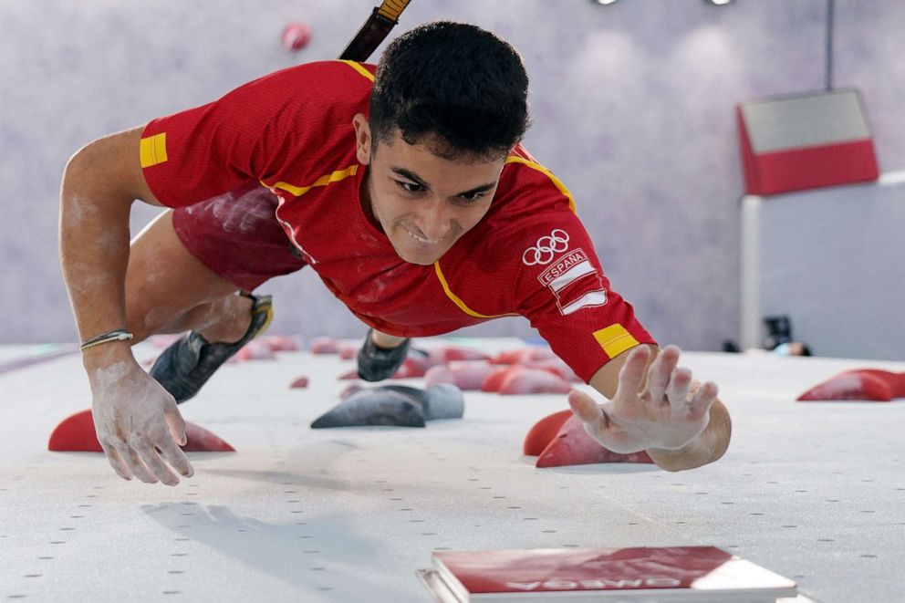 PHOTO: Spain's Alberto Gines Lopez hits the button and wins his men's sport climbing speed final against Japan's Tomoa Narasaki during the Tokyo 2020 Olympic Games at the Aomi Urban Sports Park in Tokyo on Aug. 5, 2021.