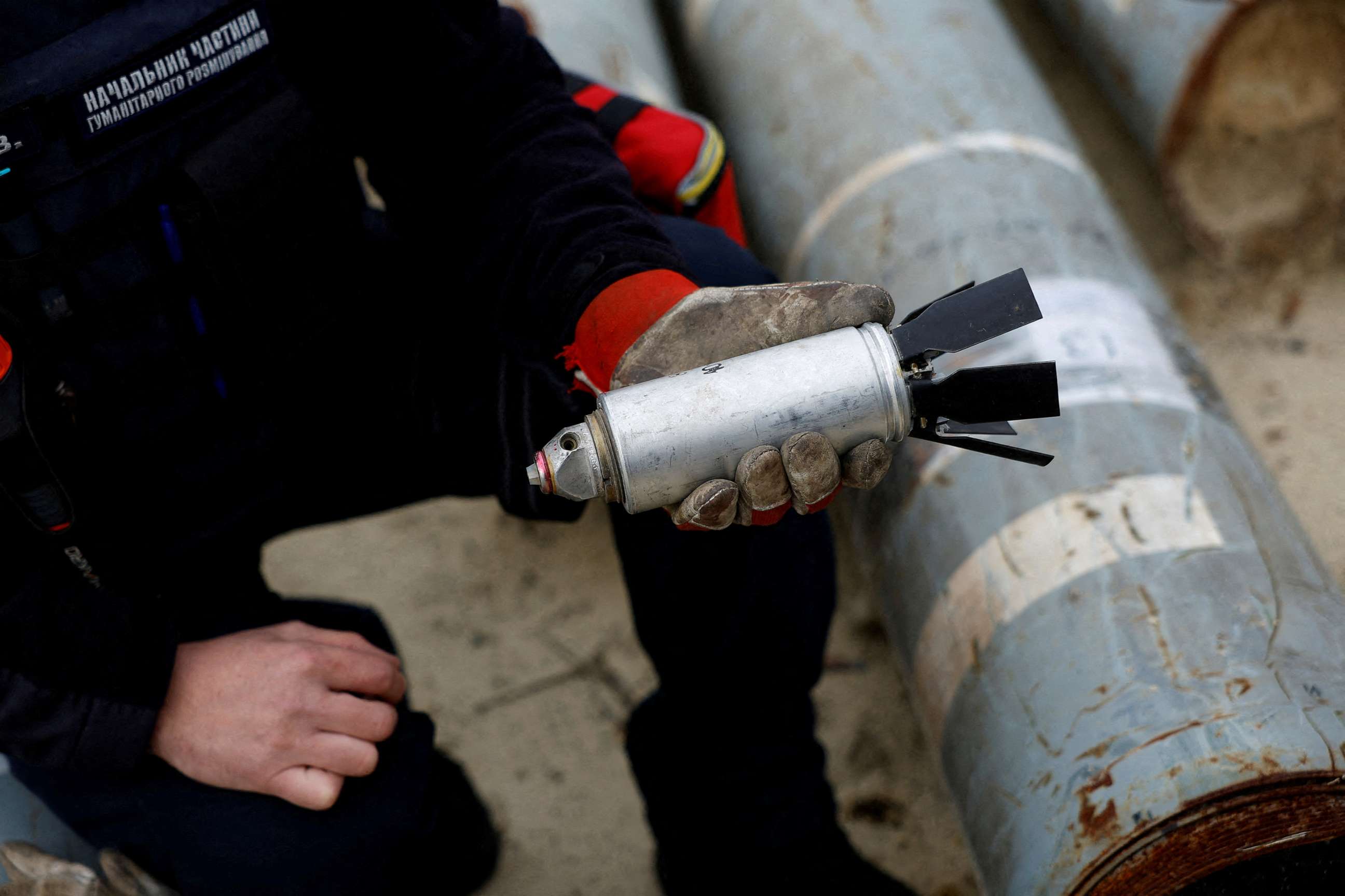 PHOTO: Ukrainian military serviceman Igor Ovcharruck holds a defused cluster bomb from an MSLR missile that a Ukrainian munitions expert said did not explode on impact, in the region of Kharkiv, Ukraine, Oct. 21, 2022.