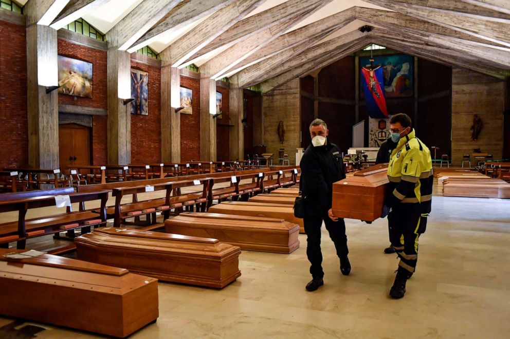 PHOTO: In this file photo taken on March 26, 2020, a coffin is carried to be aligned with others on the floor in the San Giuseppe church in Seriate, one of the areas worst hit by the coronavirus pandemic, near Bergamo, Italy.