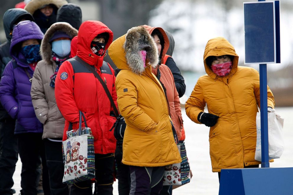 PHOTO: People bundled up against the strong winds and the cold while they wait for a bus at the Pyeongchang 2018 Winter Olympic Games, Feb. 11, 2018.