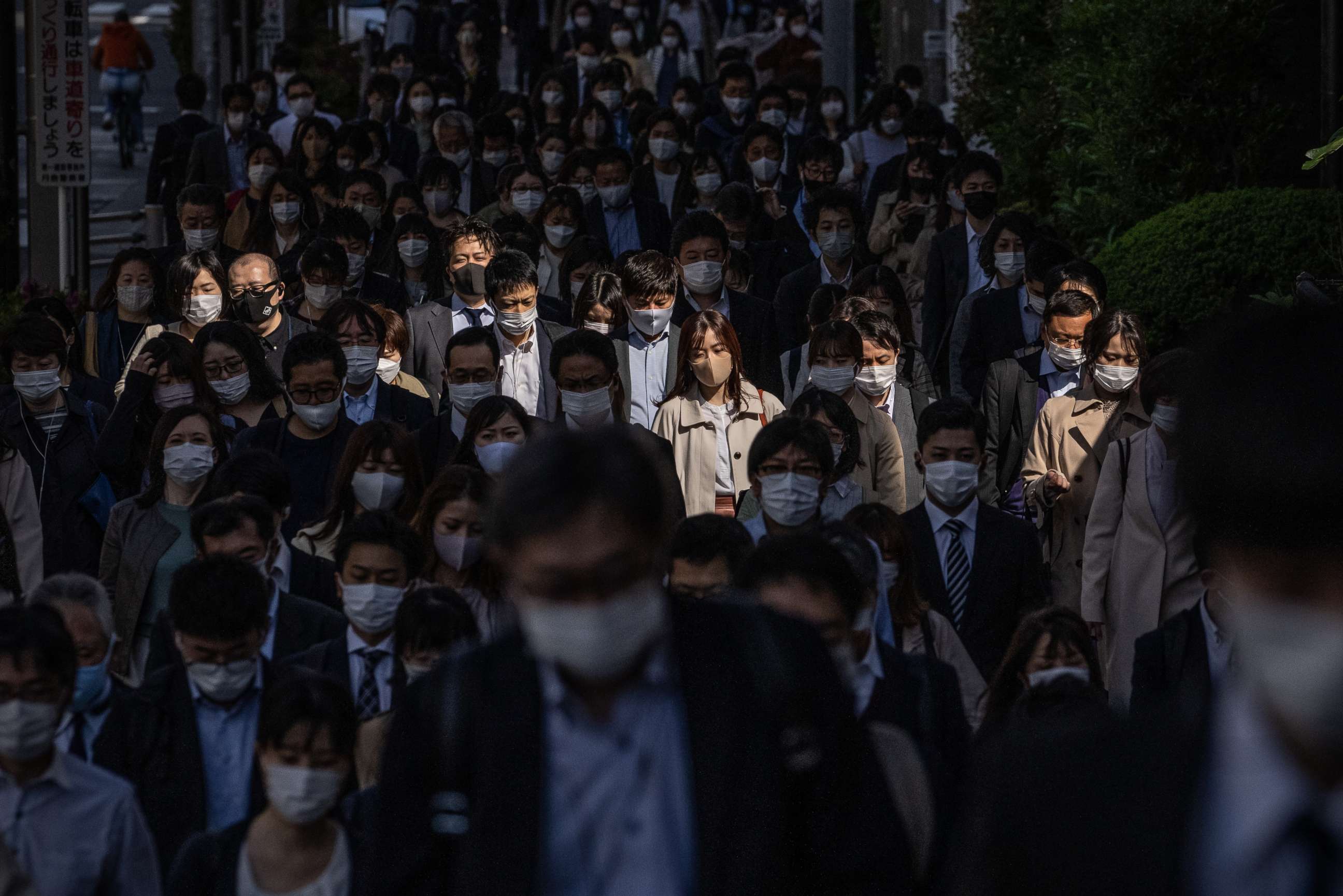 PHOTO: People wearing face masks to protect against COVID-19 walk to work in Tokyo, Japan, on April 23, 2021.