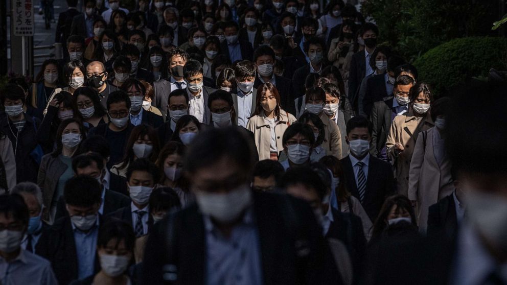 PHOTO: People wearing face masks to protect against COVID-19 walk to work in Tokyo, Japan, on April 23, 2021.