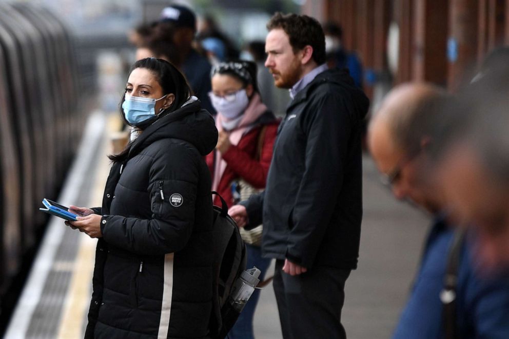 PHOTO: Commuters wearing face masks to protect against the novel coronavirus travel in the morning rush hour on underground trains from West Ham station toward central London on May 13, 2020.