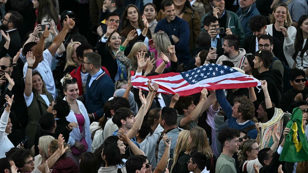 PHOTO: People wave a U.S. flag at St Peter's Square as the cardinals signaled they elected a new pope during their conclave, in The Vatican, May 8, 2025.