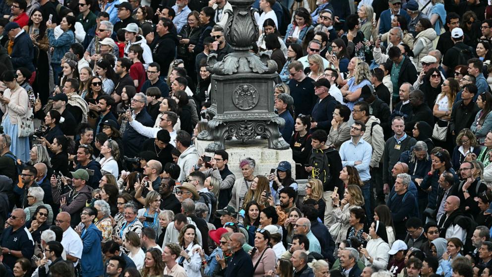 PHOTO: People wait for smoke signalling the result of the cardinals' vote during the conclave in the Vatican, May 7, 2025.