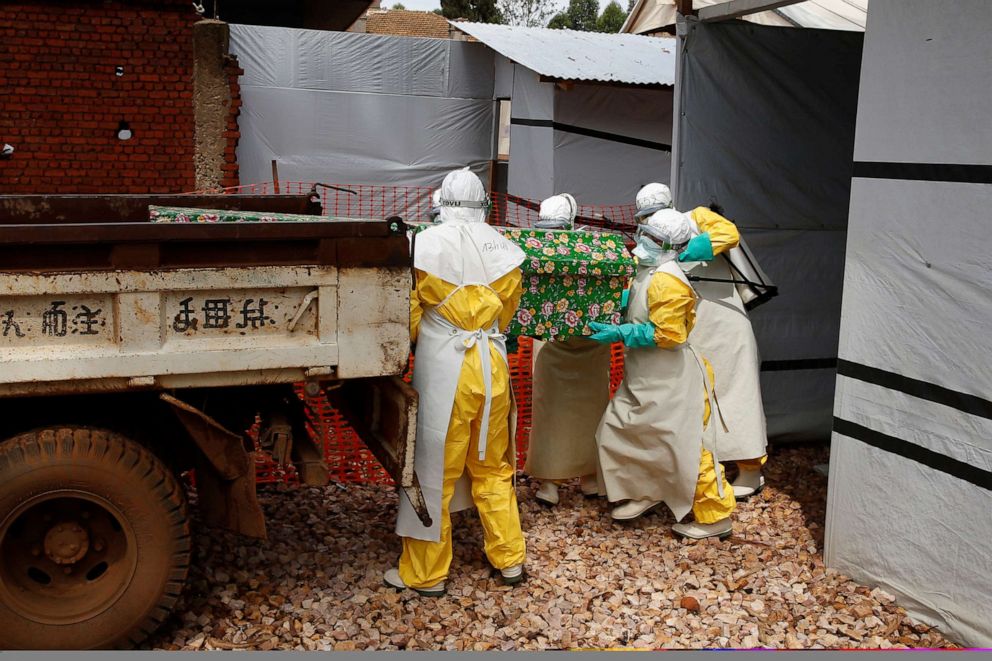 PHOTO: In this file photo, health workers dressed in protective suits place a coffin containing the body of an Ebola patient to a truck at an Ebola treatment centre in Butembo, in the Democratic Republic of Congo, March 26, 2019.