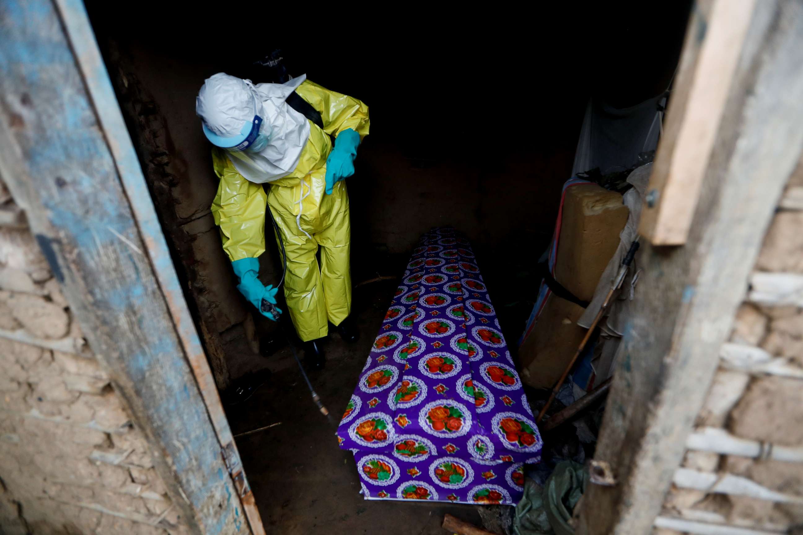 PHOTO: A healthcare worker, who volunteered in the Ebola response, sprays the coffin of a 85-year-old woman suspected of dying of Ebola, outside her house in Beni, in the Democratic Republic of Congo, Oct. 8, 2019.