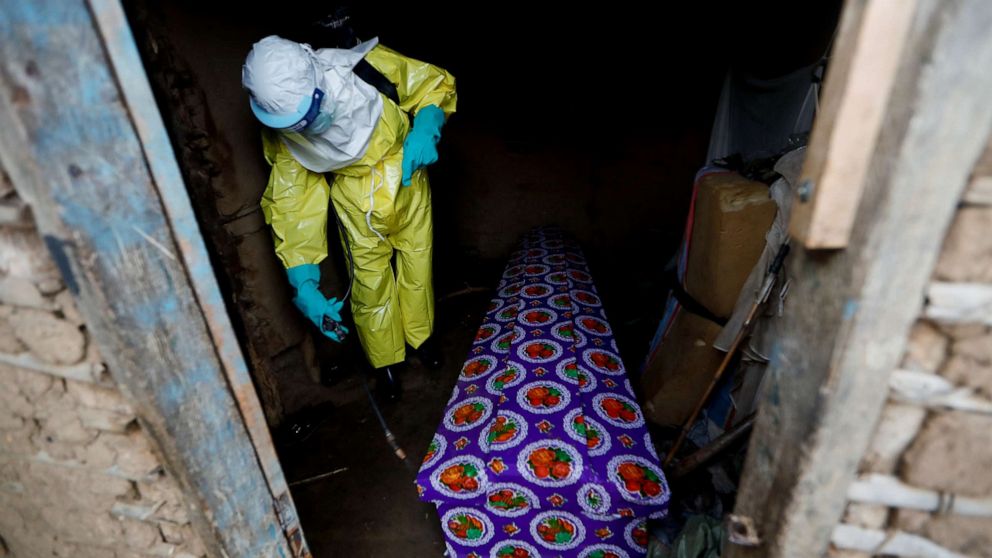 PHOTO: A healthcare worker, who volunteered in the Ebola response, sprays the coffin of a 85-year-old woman suspected of dying of Ebola, outside her house in Beni, in the Democratic Republic of Congo, Oct. 8, 2019.