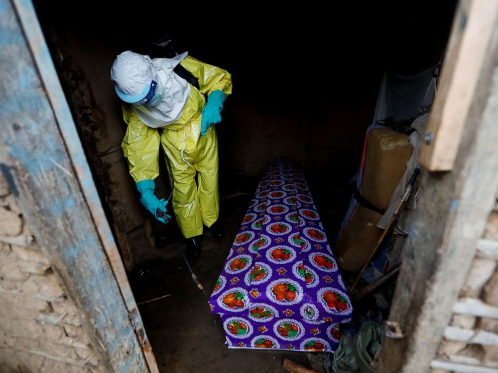 PHOTO: A healthcare worker, who volunteered in the Ebola response, sprays the coffin of a 85-year-old woman suspected of dying of Ebola, outside her house in Beni, in the Democratic Republic of Congo, Oct. 8, 2019.