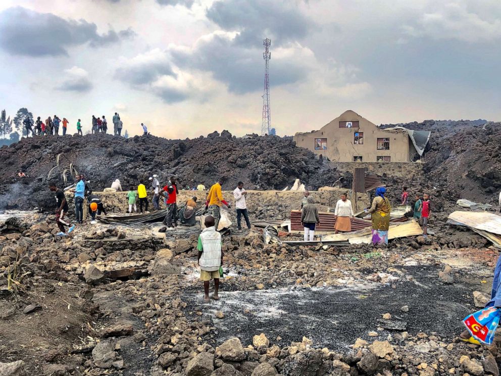 PHOTO: People gather on a stream of cold lava rock in Goma, eastern Democratic Republic of the Congo, on May 23, 2021, following the overnight eruption of Mount Nyiragongo.