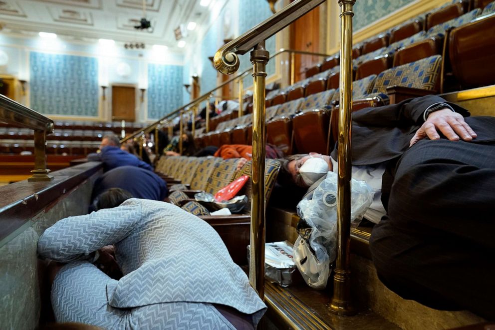 PHOTO: People shelter in the House gallery as protesters try to break into the House Chamber at the U.S. Capitol on Jan. 6, 2021, in Washington.