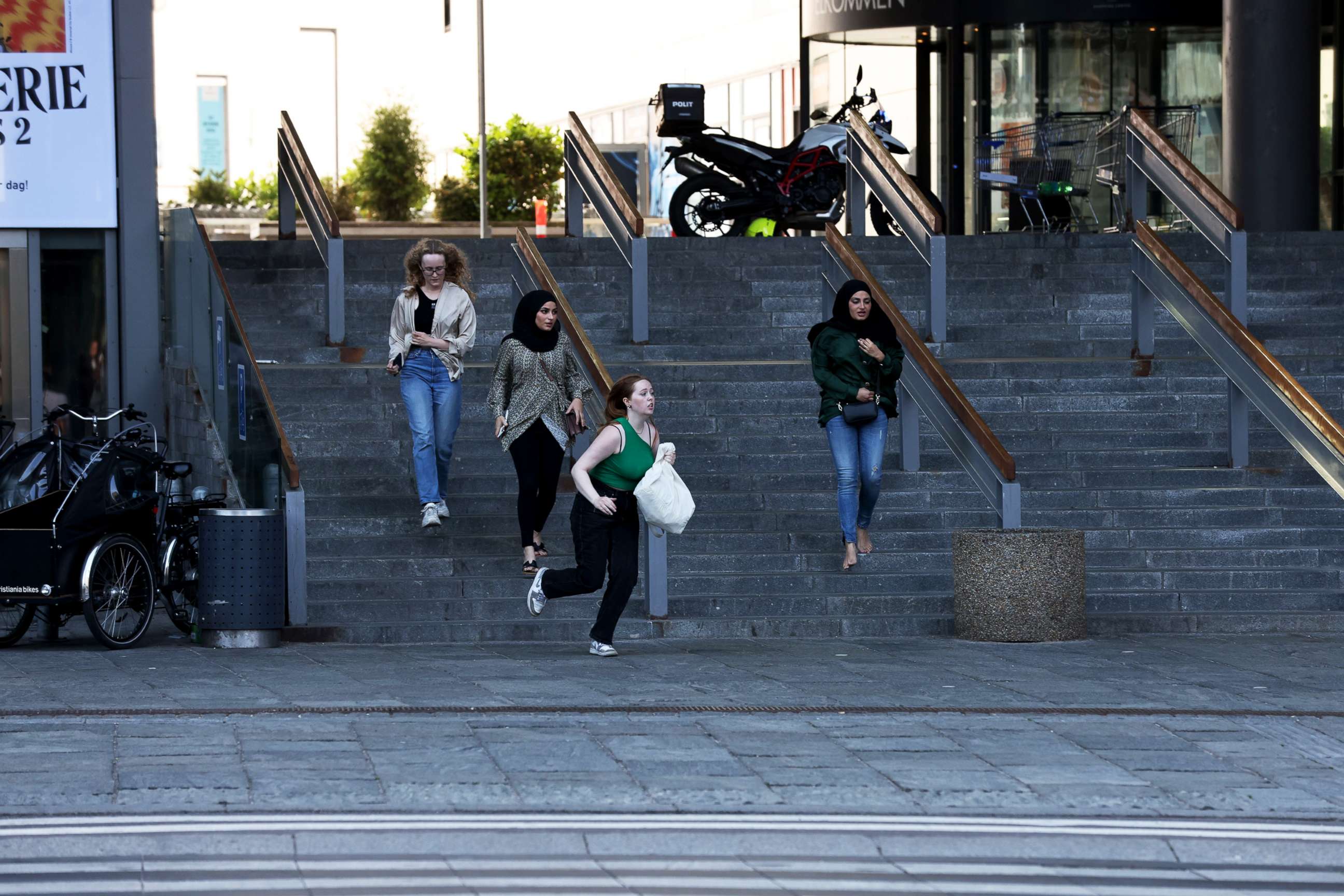 PHOTO: People run in front of the Fields shopping center after reports of shots fired in Oerstad, Copenhagen, Denmark, July 3, 2022. 