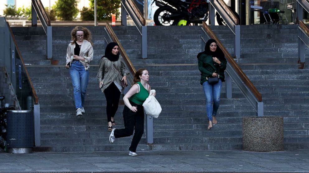 PHOTO: People run in front of the Fields shopping center after reports of shots fired in Oerstad, Copenhagen, Denmark, July 3, 2022. 