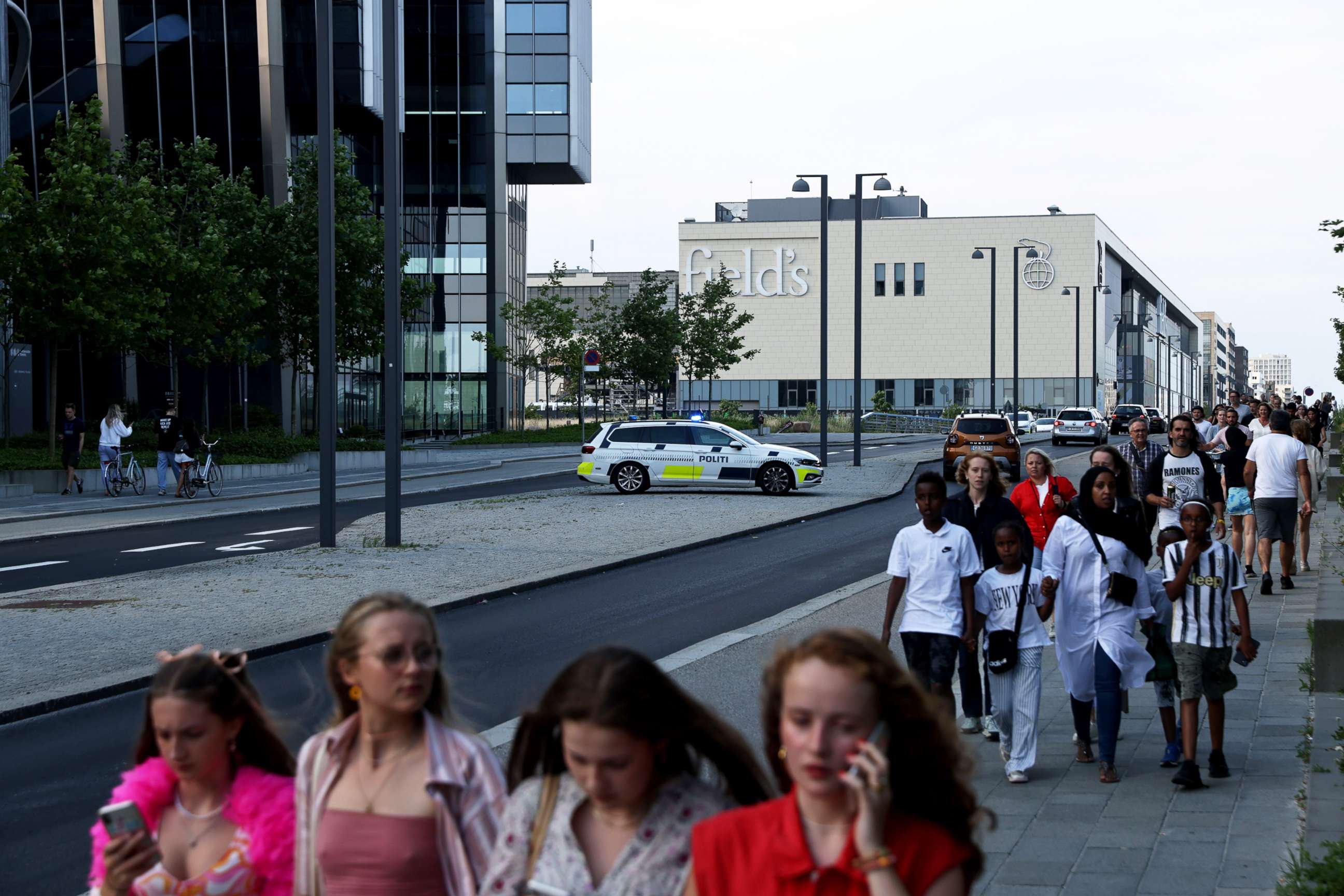 PHOTO: People gather in front of the Fields shopping center during evacuation by armed police in Oerstad, Copenhagen, Denmark, July 3 2022. 