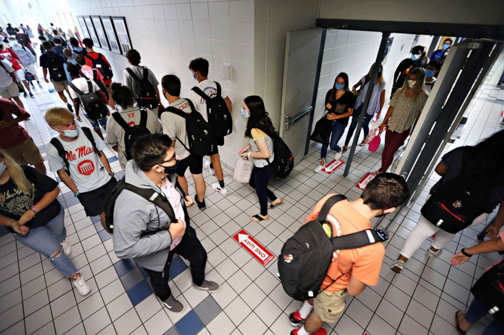 PHOTO: Corinth High School students follow the directional signage posted on the floor and keep foot traffic moving in the proper direction as they change classes on the first day back to school in Corinth, Miss., July 27, 2020.