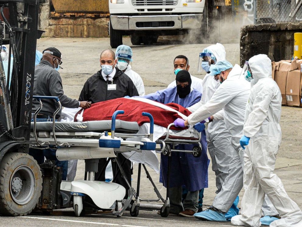 PHOTO: Dead bodies are loaded onto a truck outside Brooklyn Hospital Center, March 31, 2020. As the death toll rises NYC hospitals have using bed sheets to wrap bodies because they no longer have body bags.