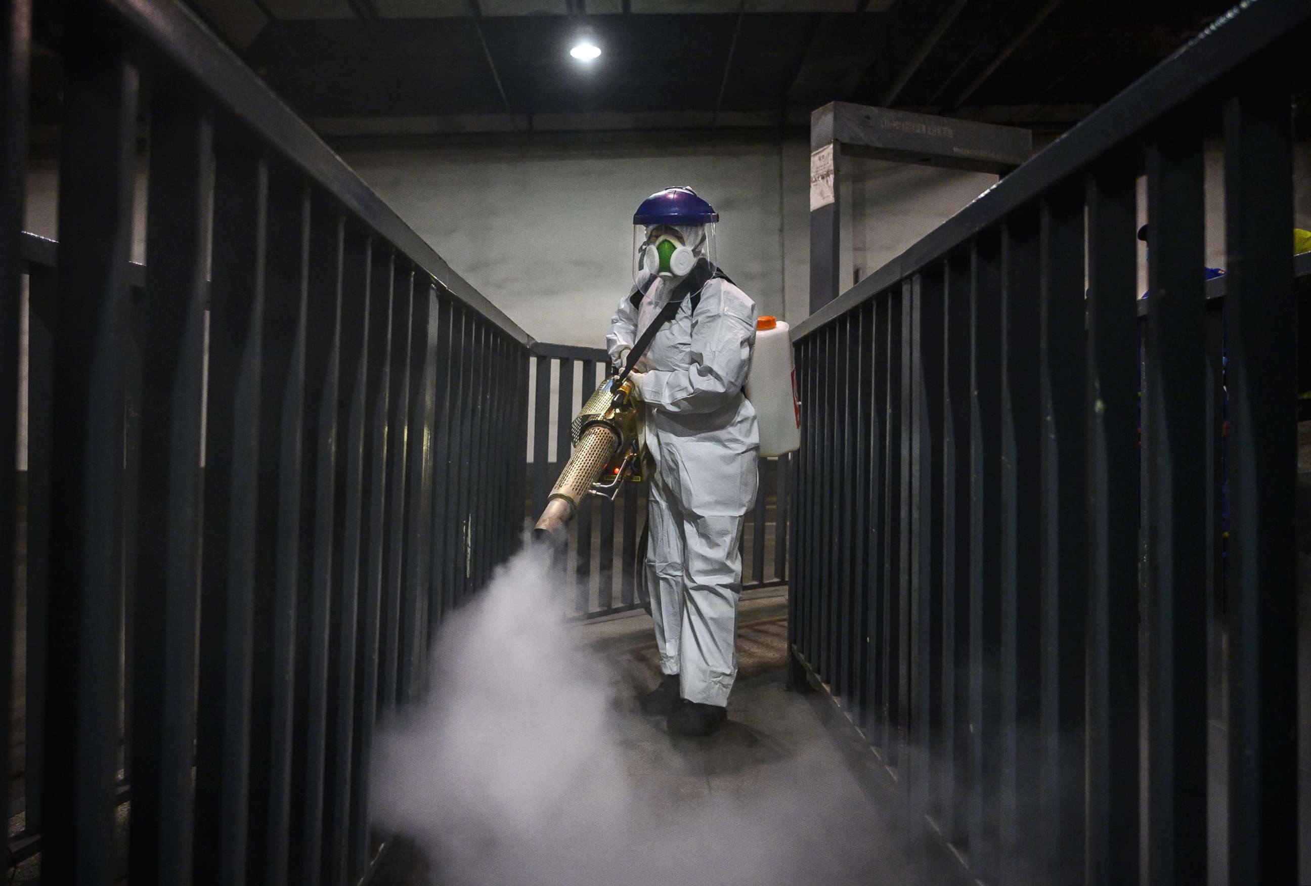 PHOTO: A volunteer from Blue Sky Rescue wears a protective suit as she fumigates and disinfects an area of a local bus station, March 7, 2020, in Beijing, China. 