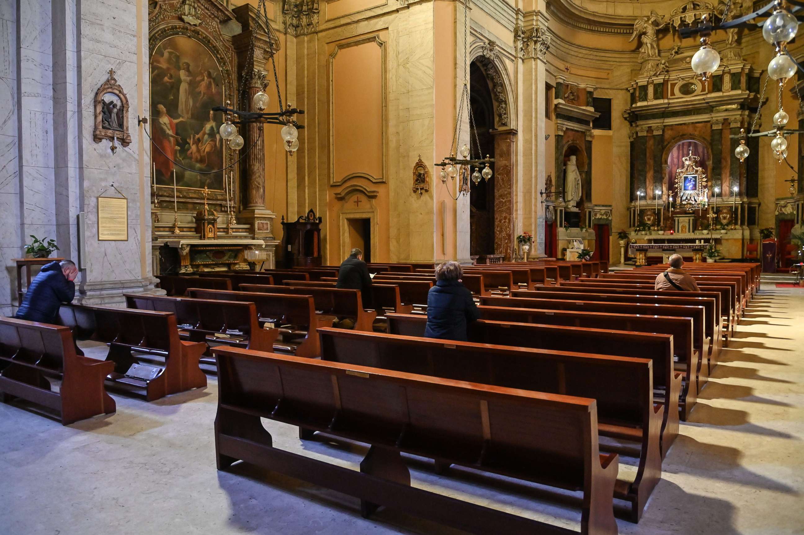 PHOTO: People pray in the church of Santa Maria delle Grazie alle Fornaci, at Aurelio district in central Rome, March 15, 2020.