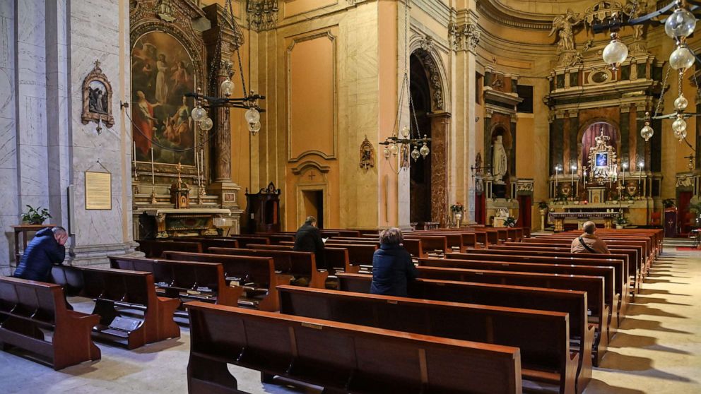 PHOTO: People pray in the church of Santa Maria delle Grazie alle Fornaci, at Aurelio district in central Rome, March 15, 2020.