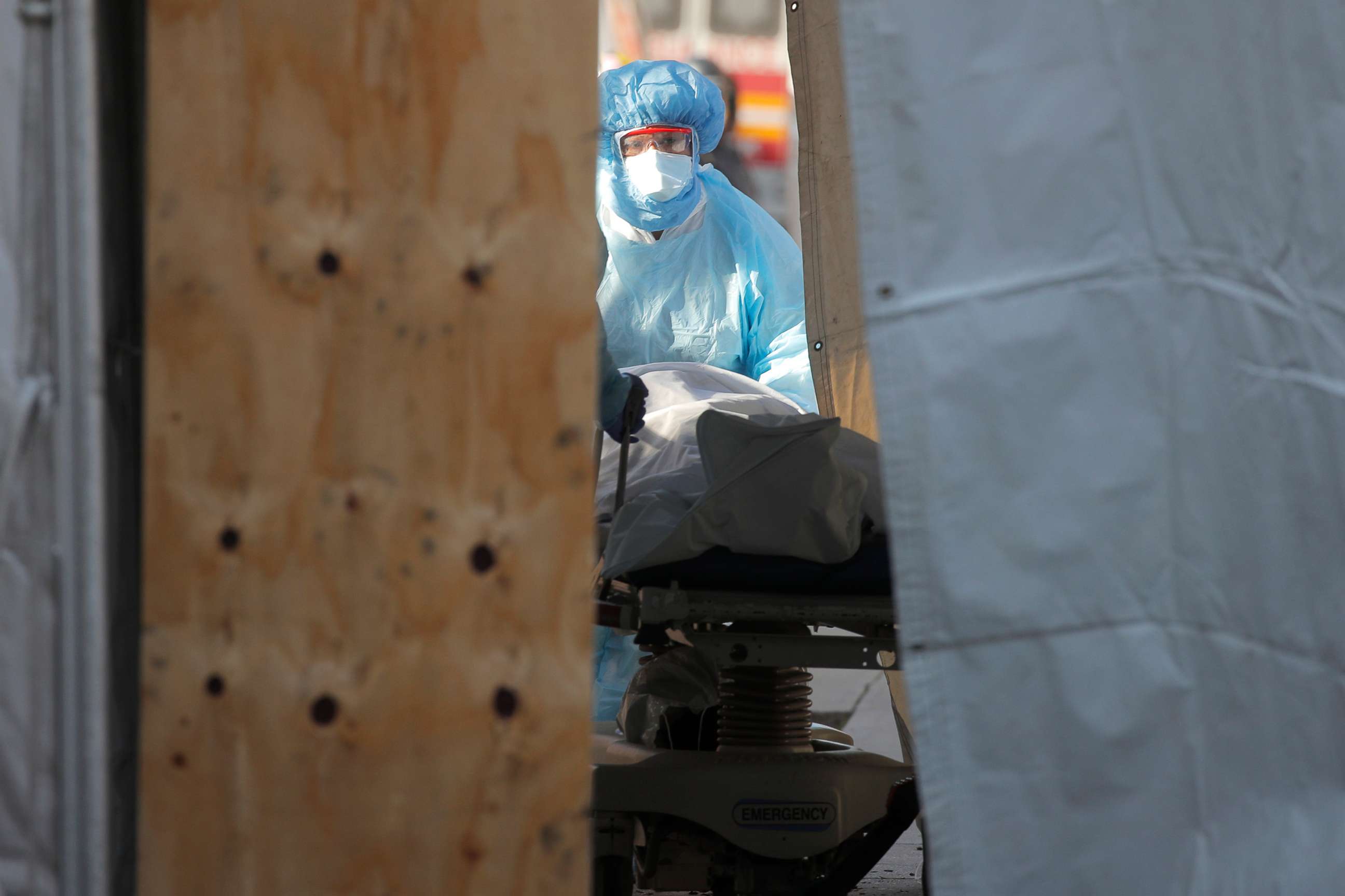 PHOTO: Healthcare workers wheels body of deceased person into makeshift morgue outside the Wyckoff Heights Medical Center during the outbreak of the coronavirus disease (COVID-19) in Brooklyn, New York, April 6, 2020. 