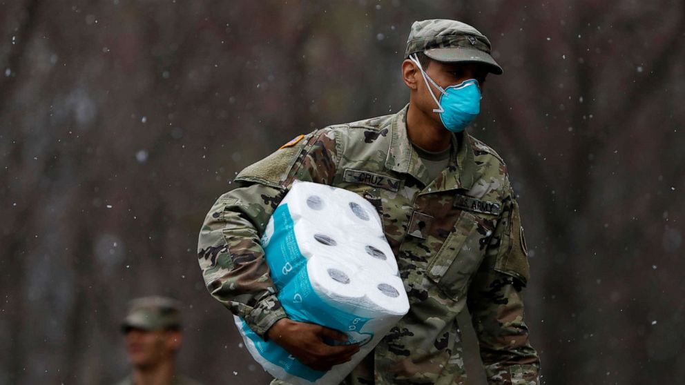 PHOTO: A member of Joint Task Force 2, composed of soldiers and airmen from the New York Army and Air National Guard, wears a face mask while carrying paper towels during the coronavirus outbreak in New Rochelle, N.Y., March 23, 2020. 