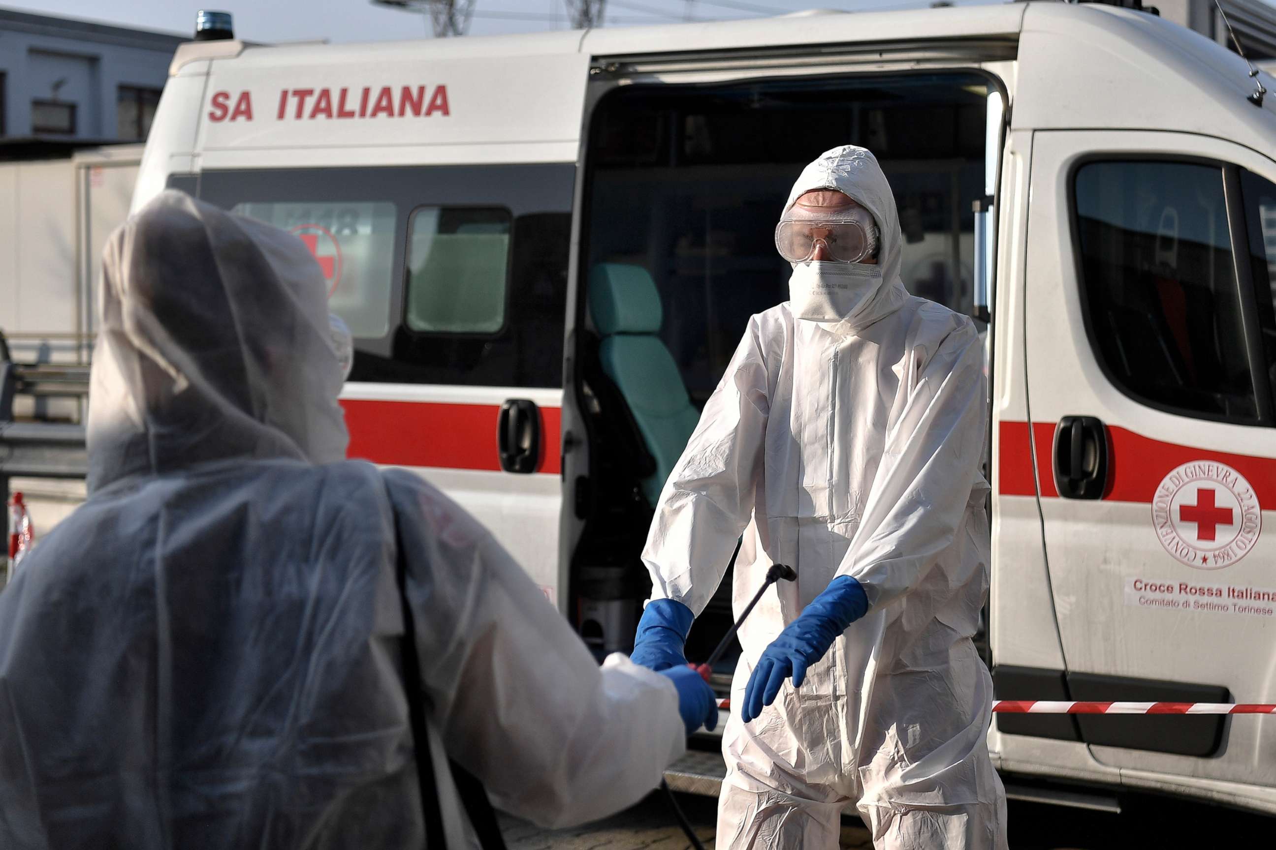 PHOTO: Operators sanitize each other after service on an ambulance for the transport of coronavirus patients in Settimo Torinese, Northern Italy, March 23, 2020. 
