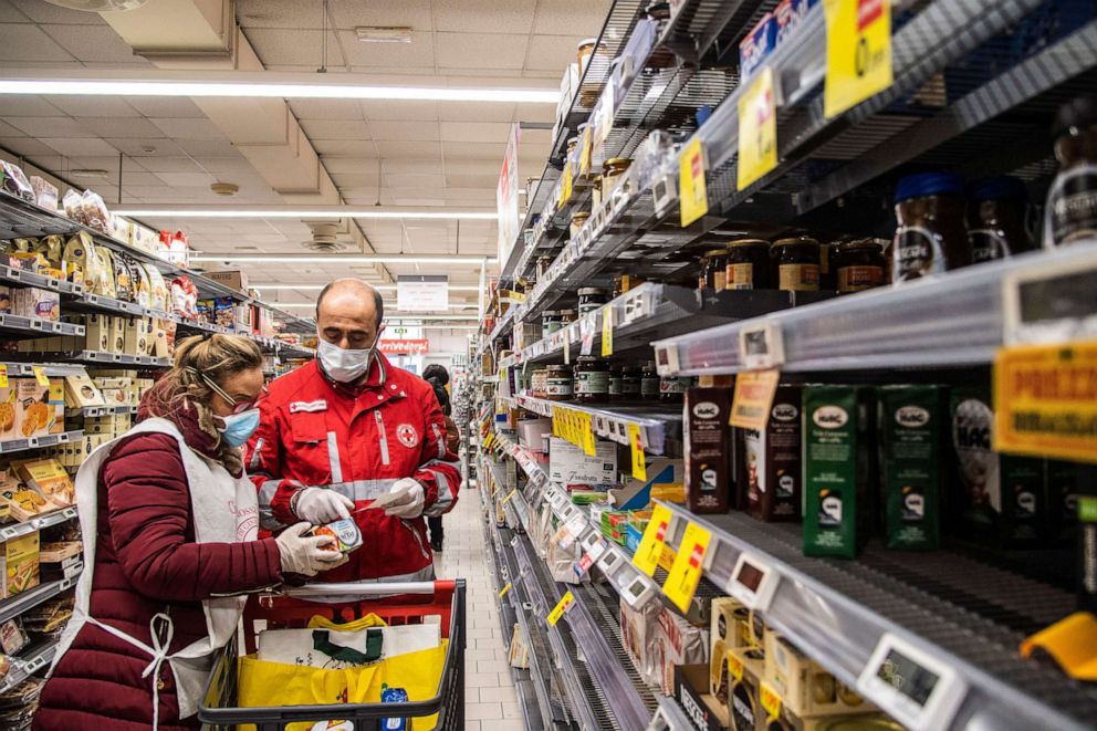 PHOTO: Volunteers from the Italian Red Cross shop at a supermarket for the home delivery service of groceries and medicines to people who are alone and unable to move during the coronavirus outbreak in Rome, Italy, March 24, 2020.