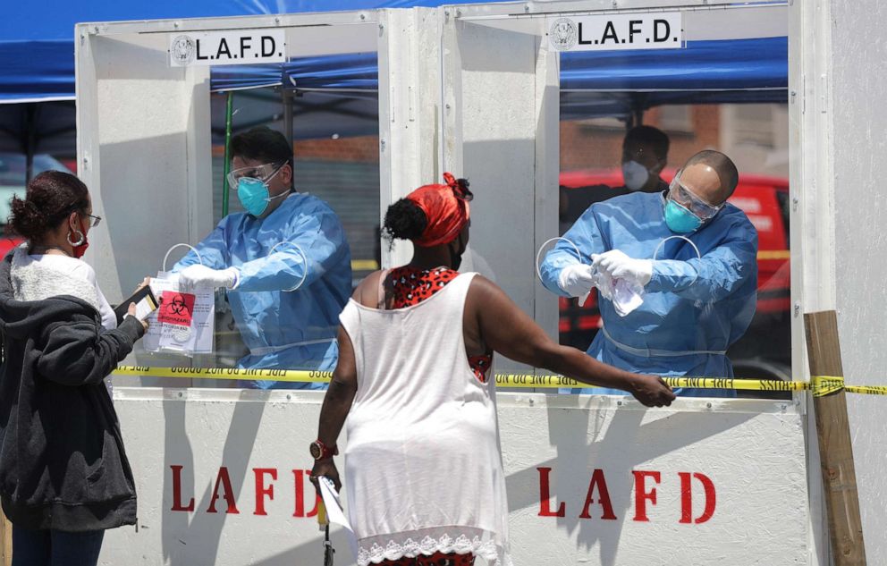 PHOTO: Women are tested for COVID-19 by members of the Los Angeles Fire Department wearing personal protective equipment in the Skid Row neighborhood of Los Angeles during the coronavirus pandemic, April 21, 2020.