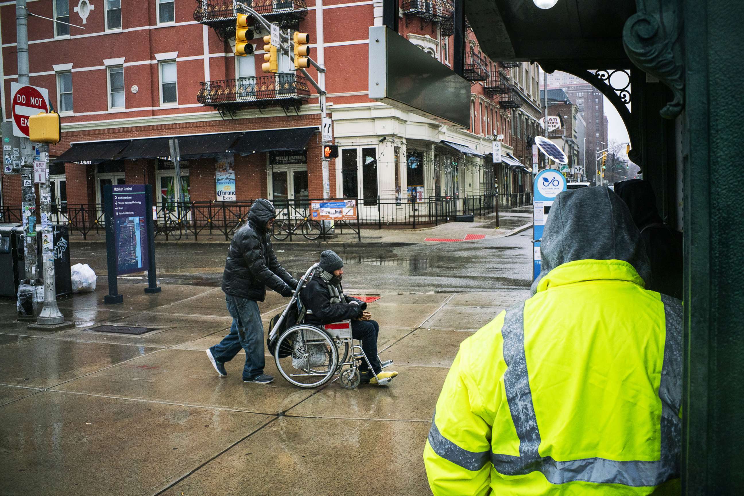 PHOTO: A man is pushed in his wheelchair to the Path train station where service operates on a weekend schedule due to the coronavirus outbreak, March 23, 2020, in Hoboken, N.J. 