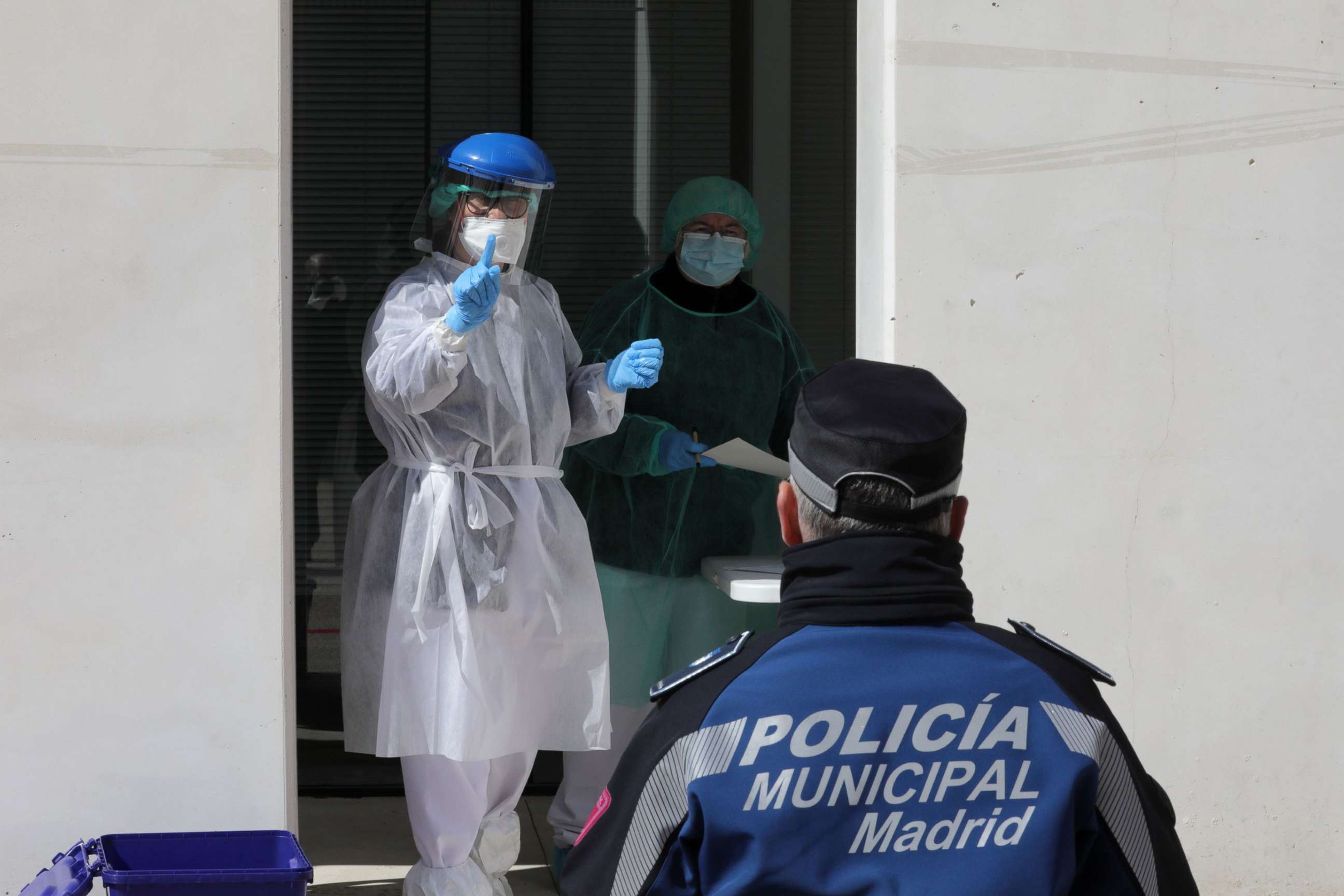 PHOTO: A health worker gestures to a municipal police officer during tests for the coronavirus in Madrid, March 25, 2020. 